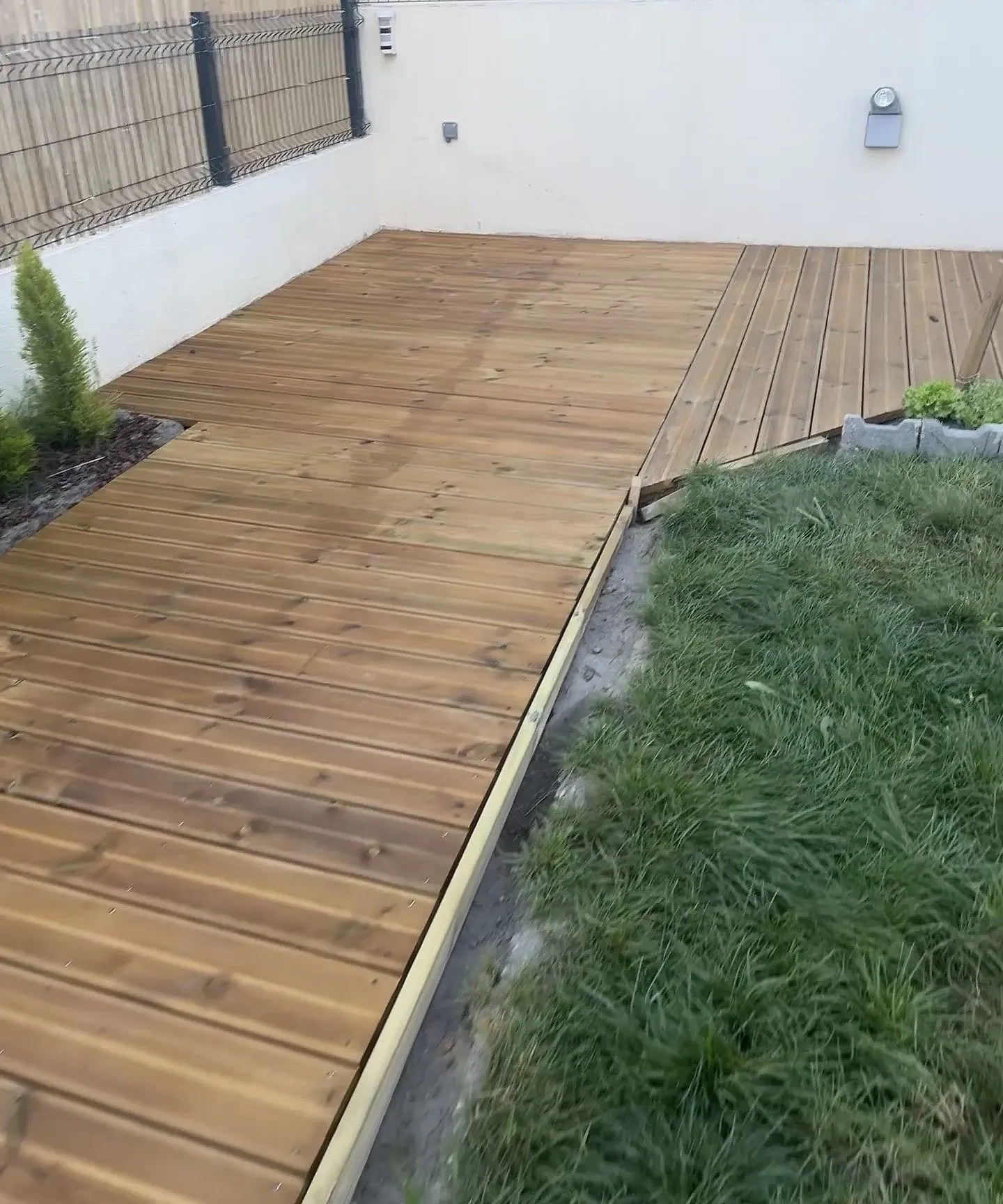 Pine decking laid along a garden lawn